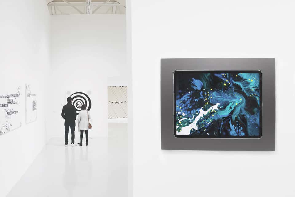Soporte de pared para iPad Pro viveroo level en una exposición de pintura